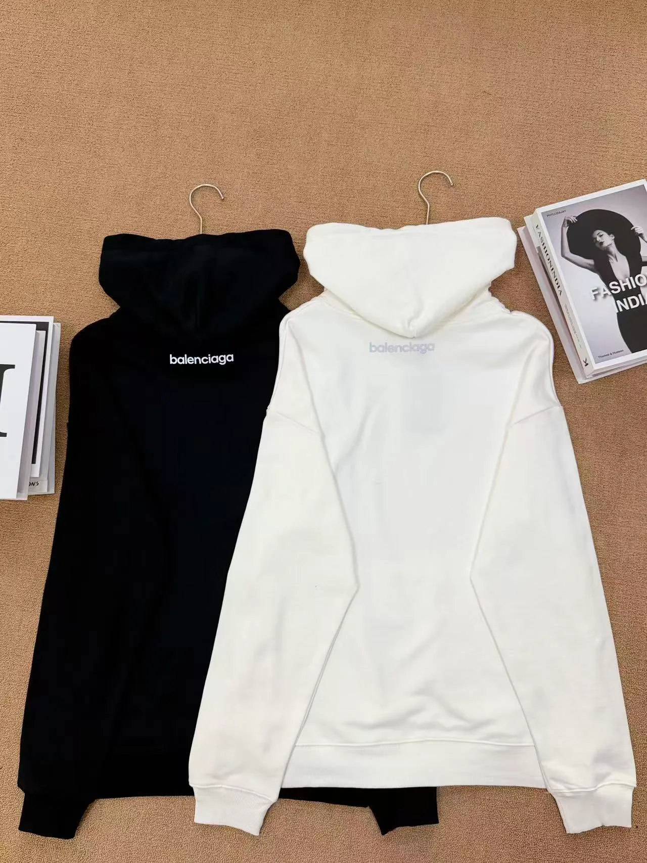 Style No. 2209 Style: Balenciaga small label embroidered hooded sweatshirt Color: Available in Black and Cream White Style: Loose shoulder wide version, same style for men and women, not picky on body shape, with a full, lazy and relaxed feel. Fabric technology: Selected 420g high-weight pure cotton terry fabric, thick and impermeable, soft and delicate to the touch. The logo is simply embroidered on the chest, and the stitching is dense and neat, making it difficult for the thread to come off. The hat has double-layer splicing, a large kangaroo pocket, the drawstring details are in place, and the cuffs and hem are tightly threaded to prevent them from loosening and deforming after long-term wear. Design highlights: Minimalist chest reflective design, no complicated printing, low-key and high-end. Basic black and white Classic color matching, Versatile is eye-catching and not easy to clash with in daily life. The loose cut makes the upper body look slimmer and is very tolerant to all body shapes. Wearing scenarios: Suitable for daily commuting, shopping, and traveling. The bottoms can be paired with jeans, sports pants, or skirts. They can be worn alone. They also look great when paired with a jacket in autumn and winter. A pair for couples will create a great atmosphere.